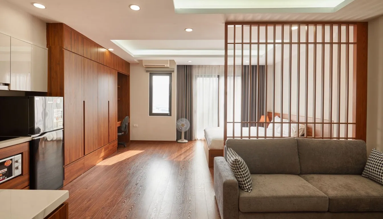 A compact studio apartment with a sofa, slatted room divider and built-in wood storage