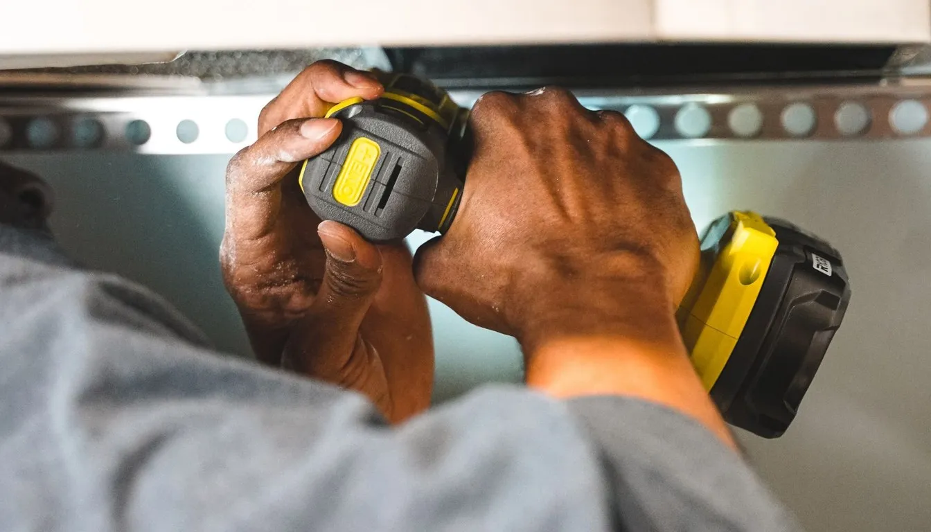 Hands driving a screw with a cordless drill