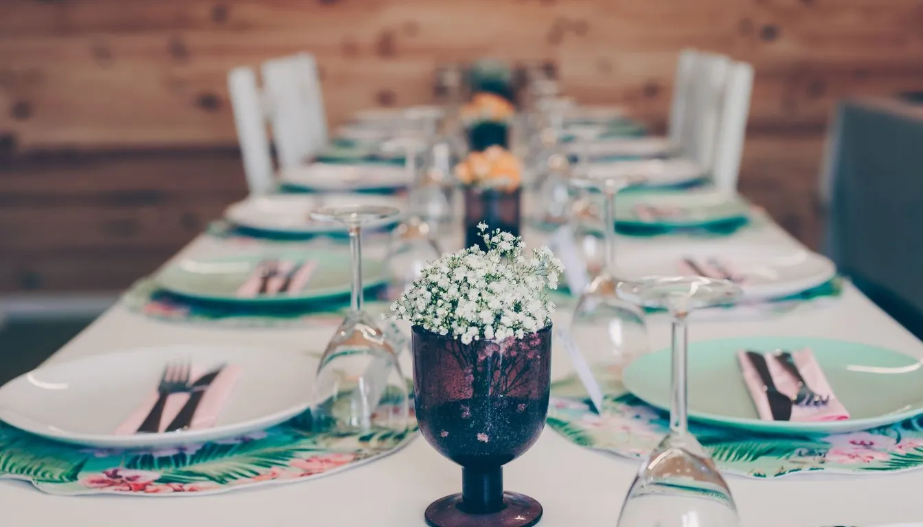 Table set with decorative charger plates, glasses, and a floral centerpiece