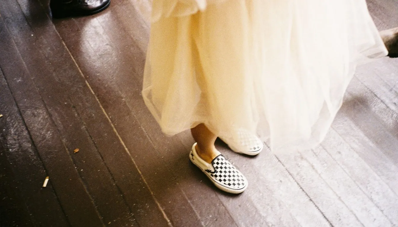 A checkered slip-on shoe stepping across a wooden floor