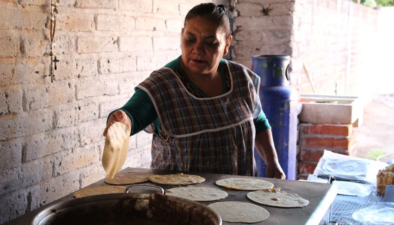 Woman cooking tortillas on a traditional comal