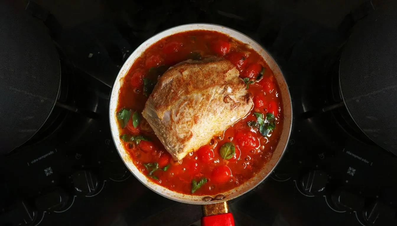 Braised meat in tomato sauce cooking in a heavy pot
