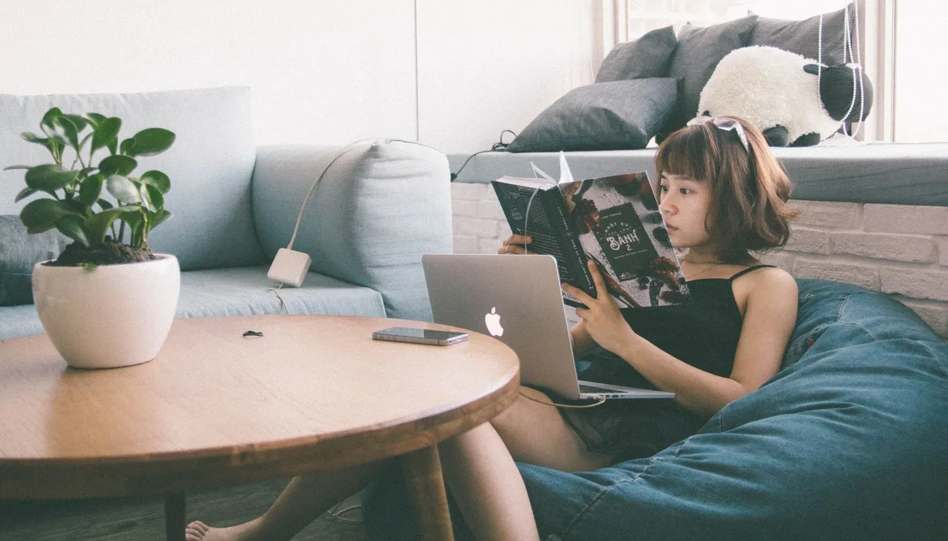 Woman reading on a bean bag chair in a living room