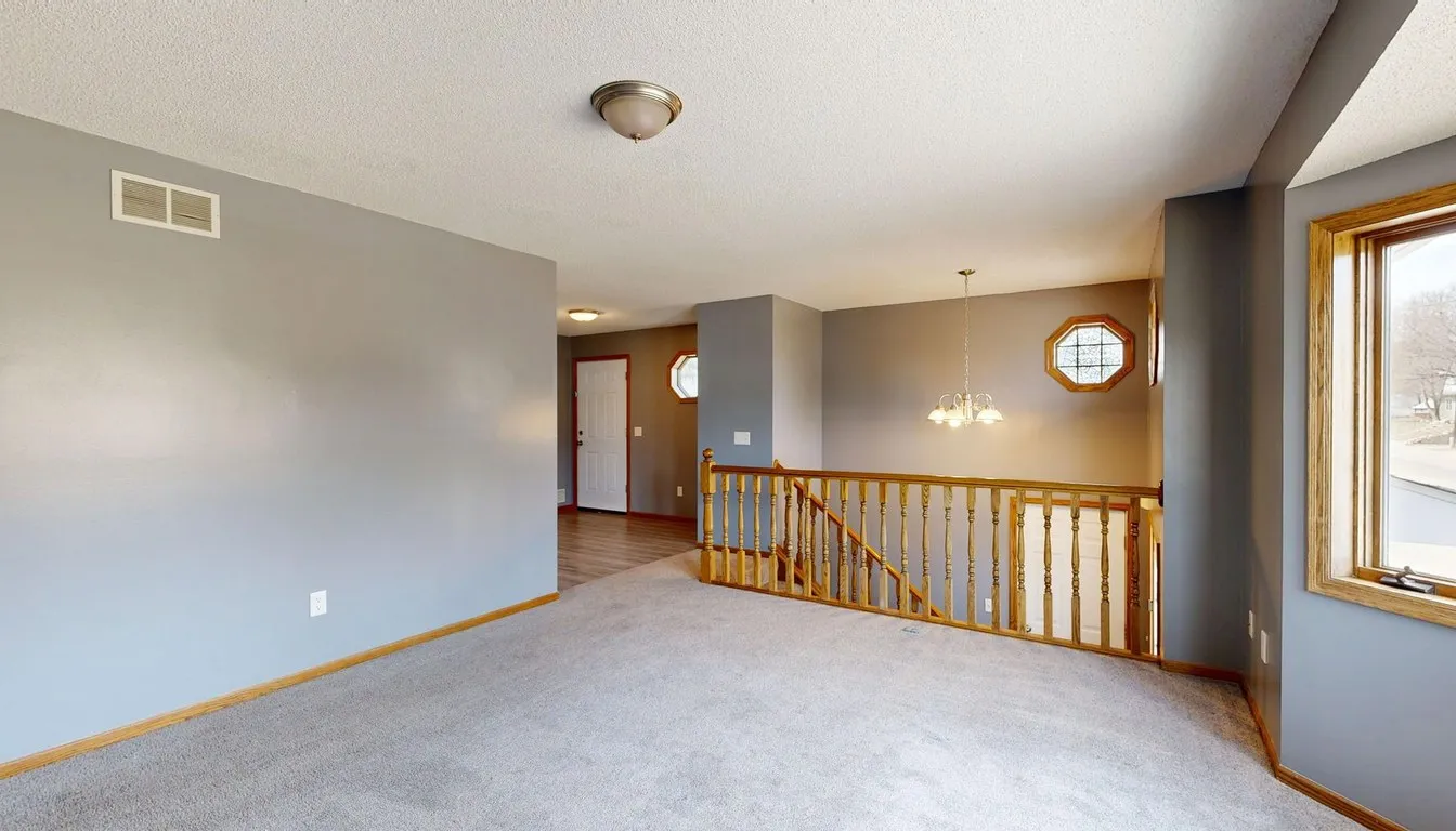 Empty carpeted room with daylight from the windows