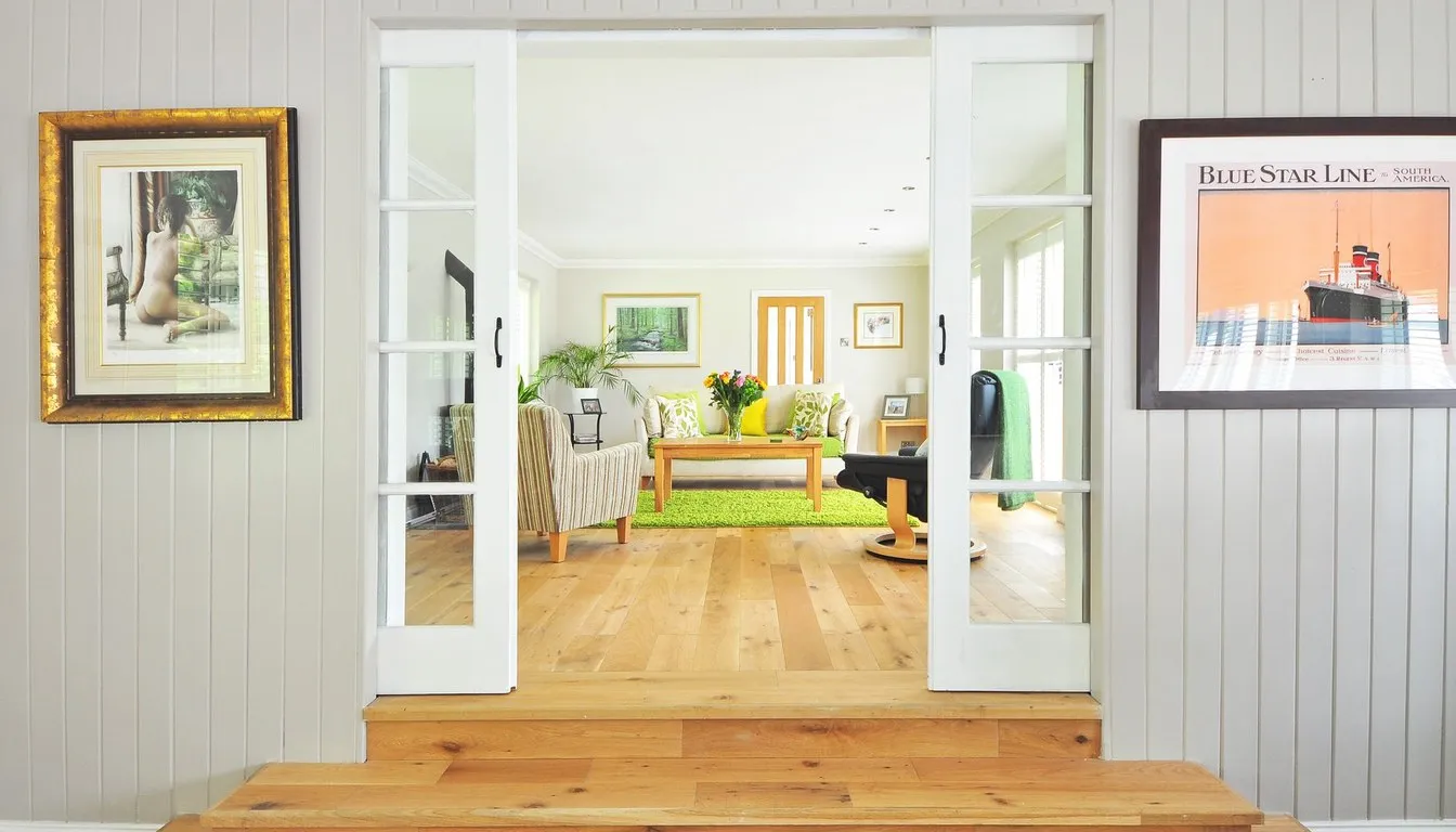 Open double glass-paneled doors leading into a bright living room