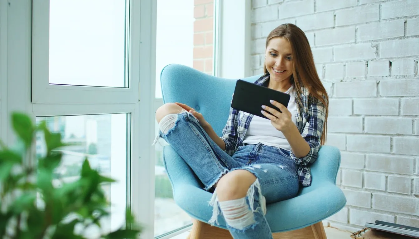 Woman on an armchair browsing a tablet