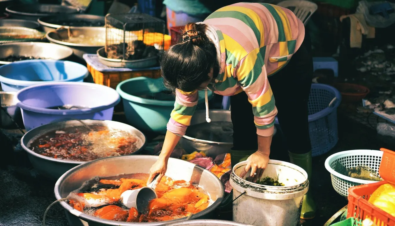 Woman hand-washing colorful clothes in large basins