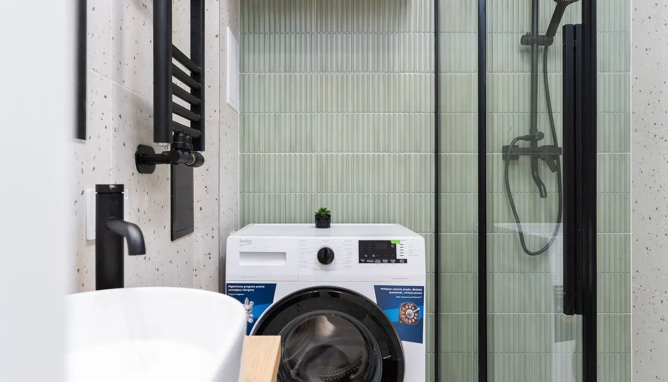 White washing machine in a tiled bathroom laundry corner