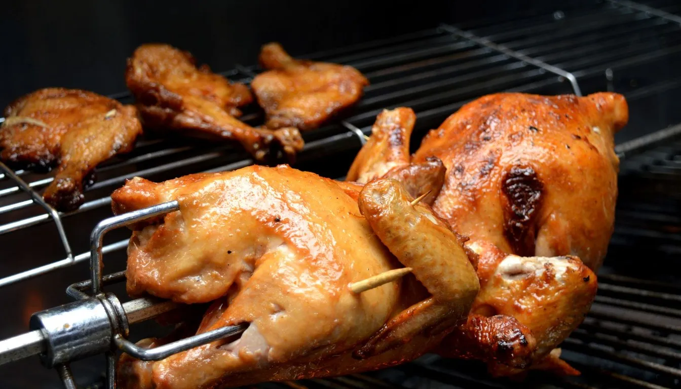 Chickens roasting on a rotisserie grill
