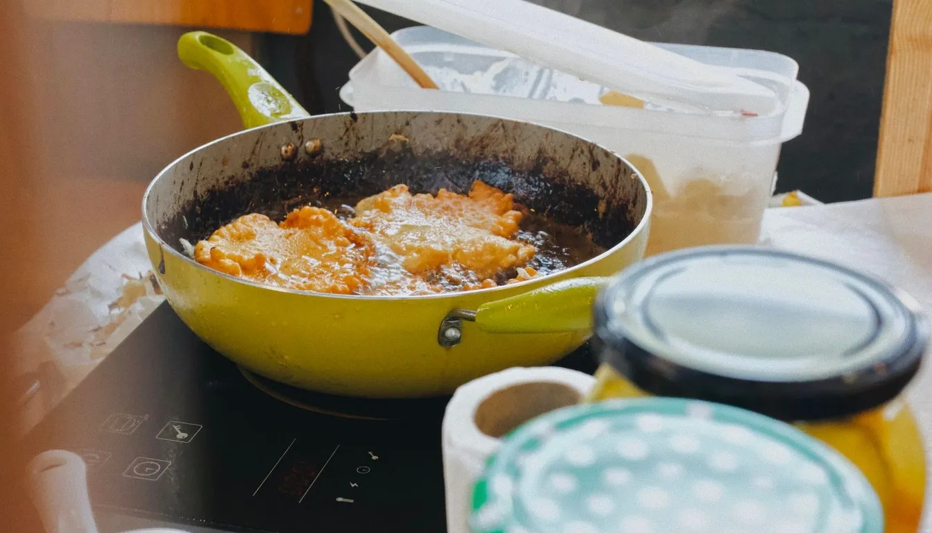 Food frying in a yellow pan on a portable stove