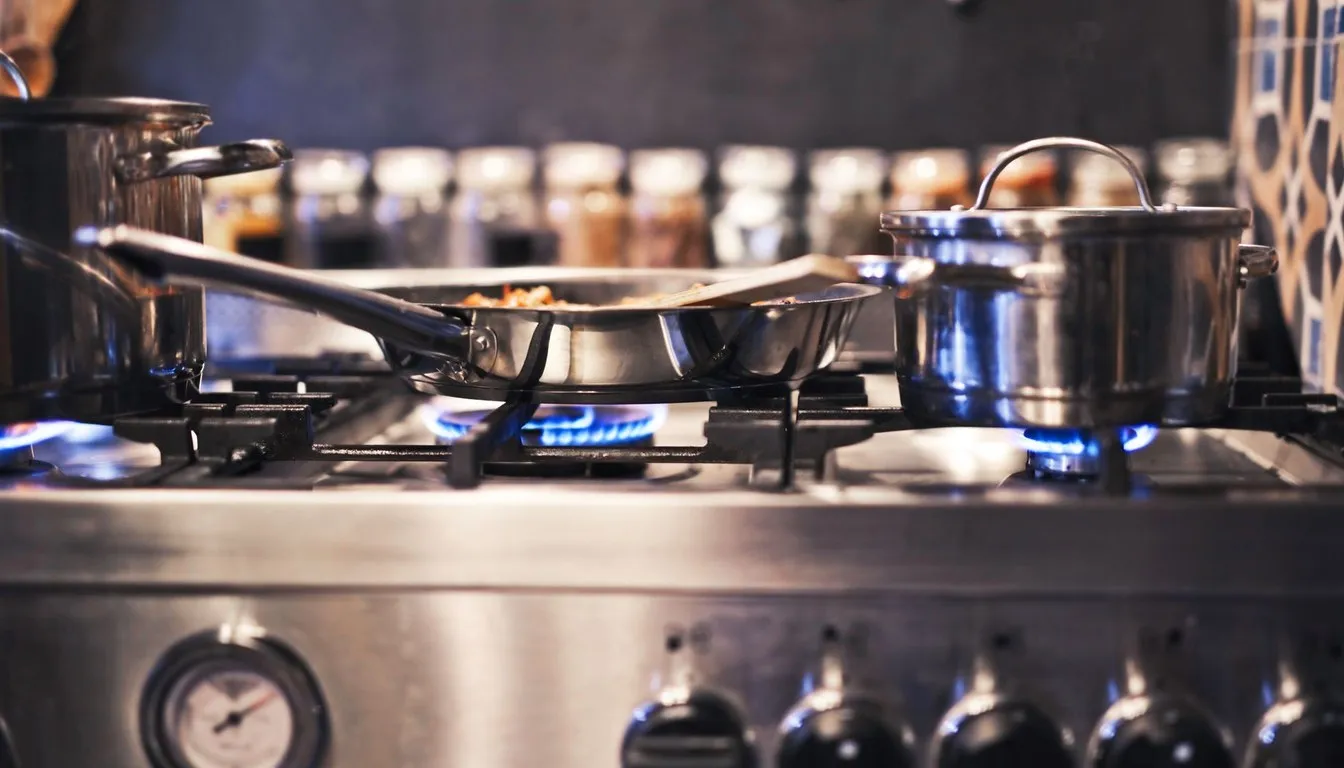 Stainless steel pots and pans on a commercial gas range