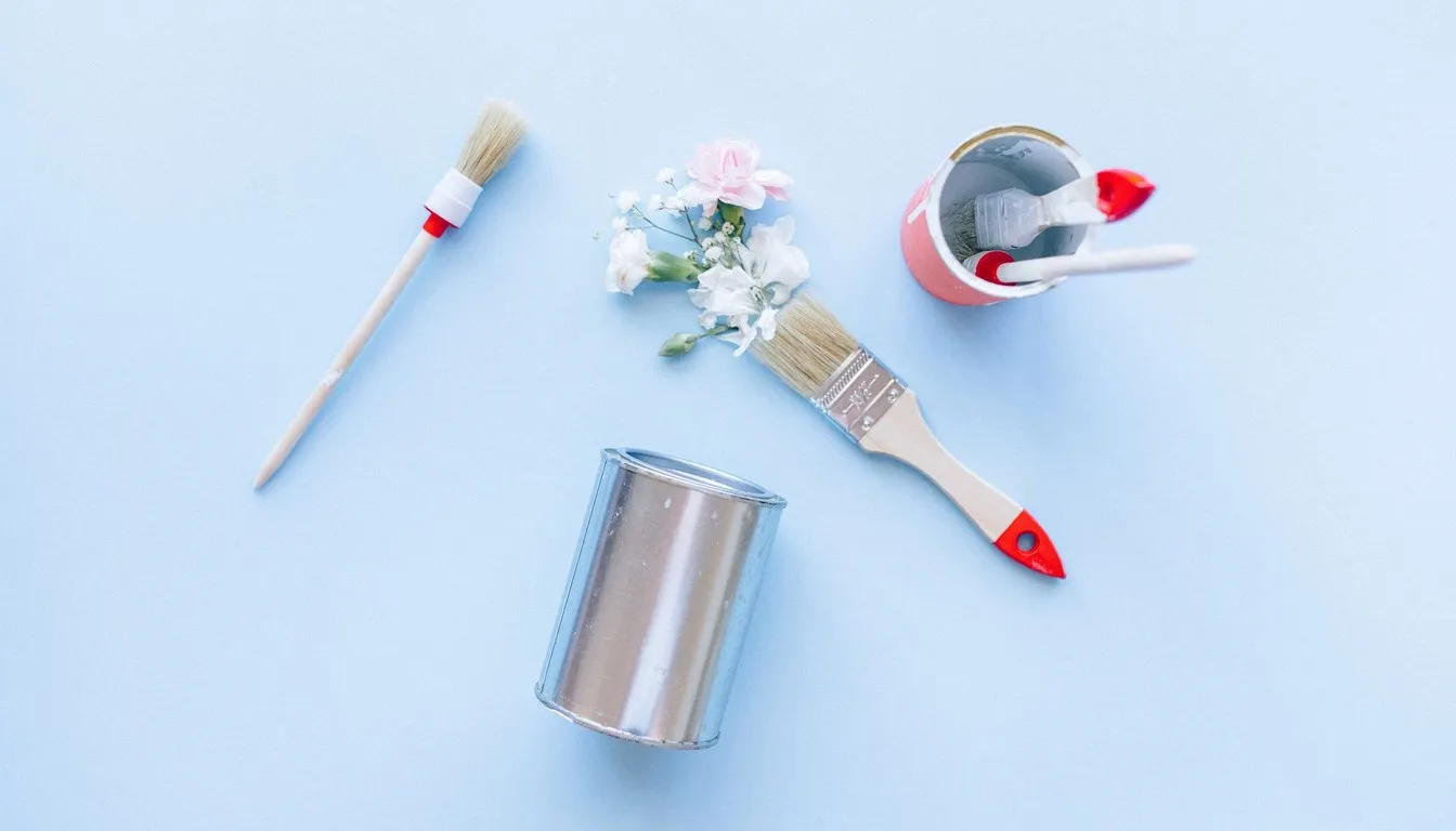 Paint brushes and a metal tin on a blue background